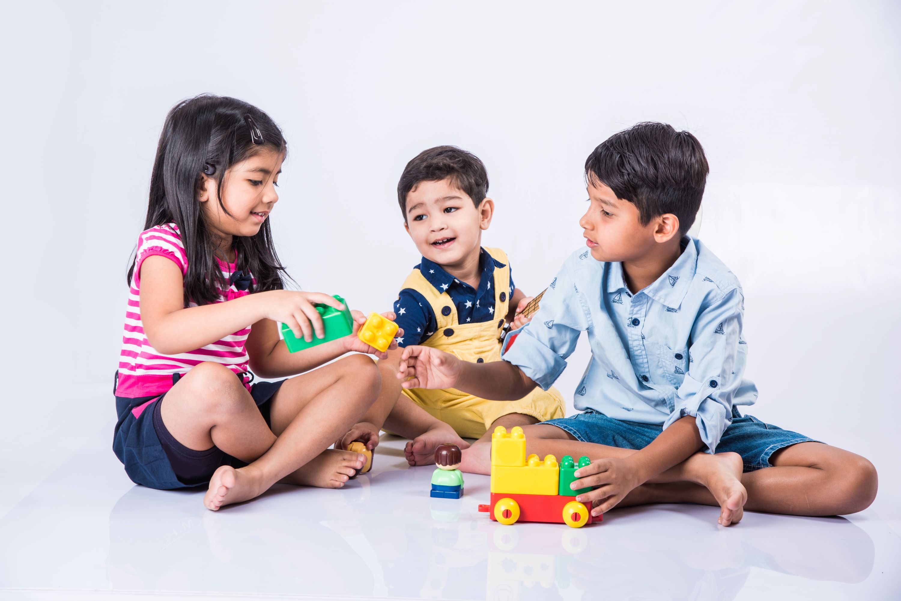 Three children play with colorful toys